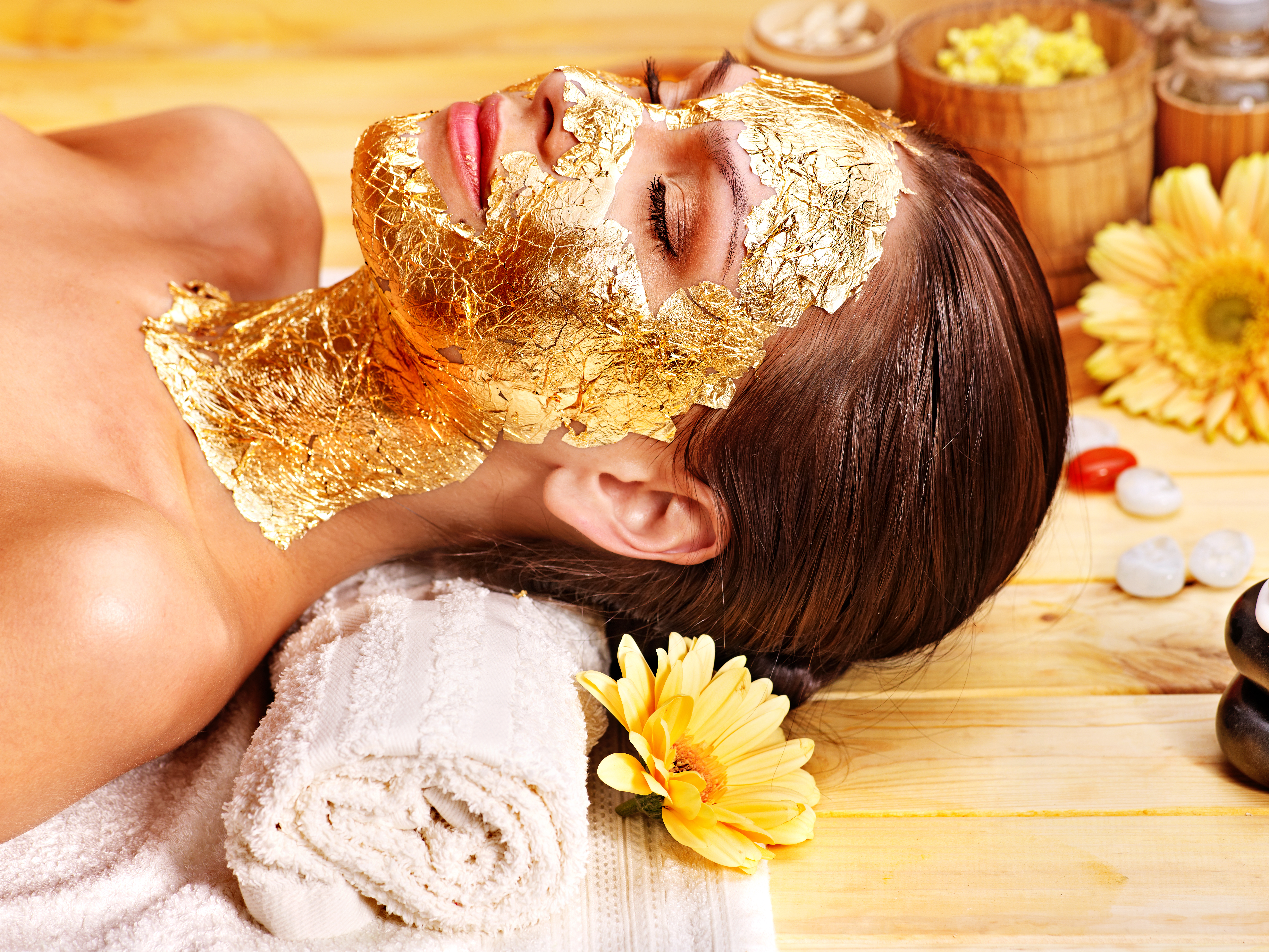 a woman with gold facial cream